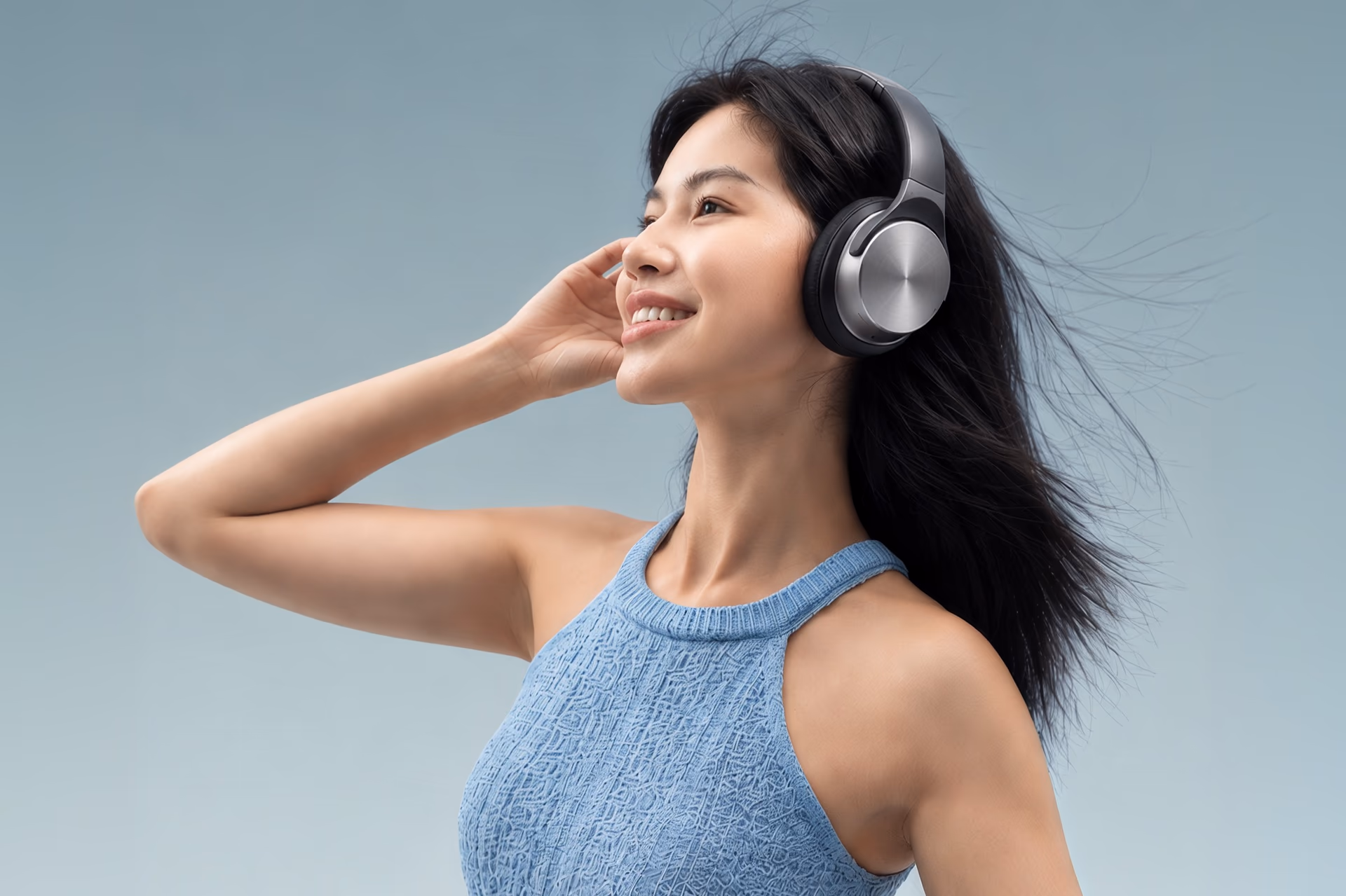 A woman with windswept hair wearing Sonicra headphones
